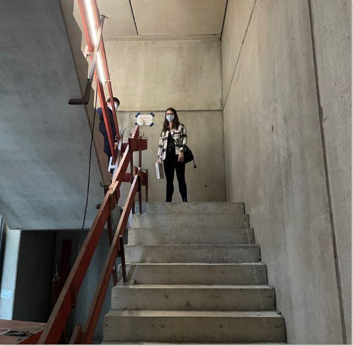 Eine Frau mit Maske steht auf der Treppe.